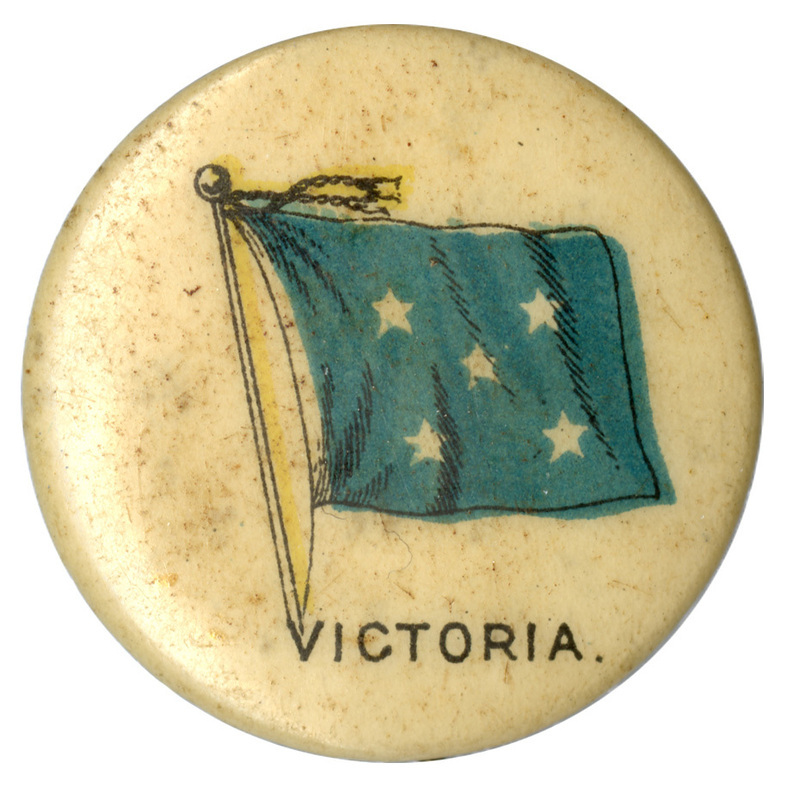 Round, white button with a color illustration of a flag with five white stars on a field of blue. Black text at the bottom reads "VICTORIA."