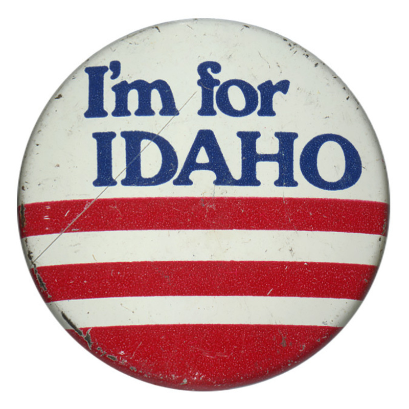 Round, white button with red horizontal stripes in the lower half and blue text in the upper half reading "I'm for IDAHO"