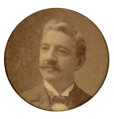 Round button with a portrait of Benjamin Odell.