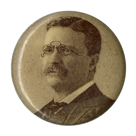 Round, off-white button with a black and white portrait of Theodore Roosevelt at the center. 