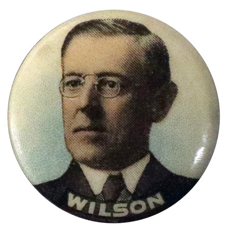Round, white button with a portrait of Woodrow Wilson, and white text at the bottom reading "Wilson". 