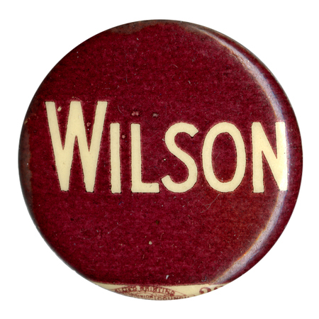 Round, burgundy button reading "Wilson" in white text.