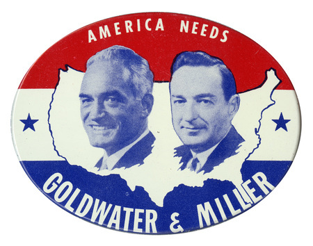 Oval button with red and blue bands and an outline of the United States overlaid with portraits of Barry Goldwater and William Miller. The text reads: "America Needs Goldwater & Miller."