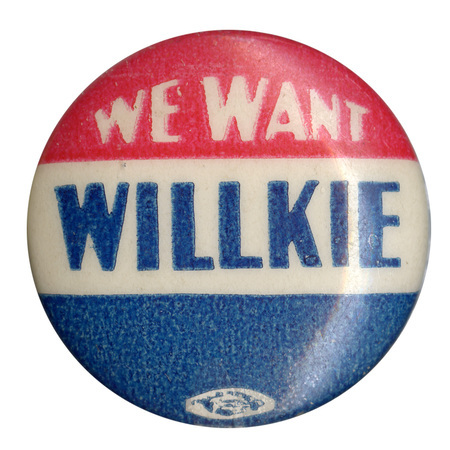 Round button with three horizontal stripes of red, white, and blue. White text reads "We Want" across the top, red stripe, and blue text reads "Willkie" across the center, white stripe.