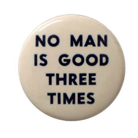 Round, white button with dark blue text reading "No man is good three times".