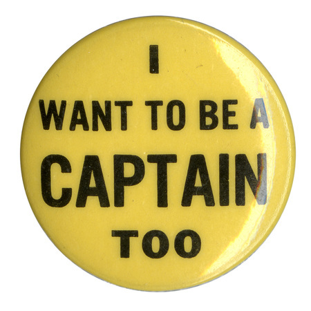Round, light yellow button with black text reading "I want to be a captain too". 