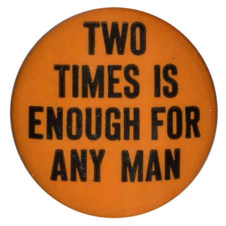 Round, orange button with black text reading "Two times is enough for any man".