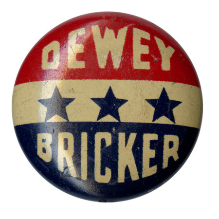 Round, white button with a partial red border, and two grayscale portraits of Thomas Dewey and John Bricker. White text on red border reads "Dewey Bricker". 