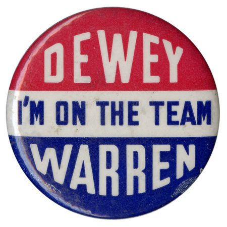 Round button with three horizontal stripes with red, white, and blue. White and blue text reads "I'm on the team Dewey Warren". 