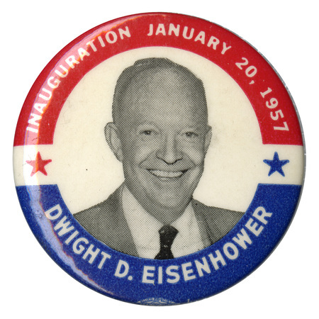 Round, white button with a blue and red border and a grayscale portrait of Dwight D. Eisenhower. White text encircling the portrait reads "Inauguration January 20, 1957 Dwight D. Eisenhower". Two decorative stars are on either side of the portrait. 