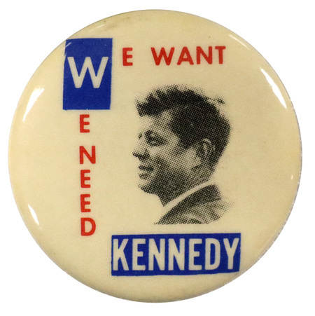 Round, white button with a grayscale portrait of John F. Kennedy. Text reads "We want we need Kennedy". 