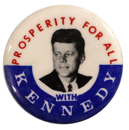 Round, white button with a blue border at the bottom and a grayscale portrait of John F. Kennedy at the center. Text reads "Prosperity for All with Kennedy". 