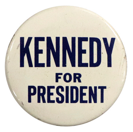 Round, white button with blue text reading "Kennedy for President". 
