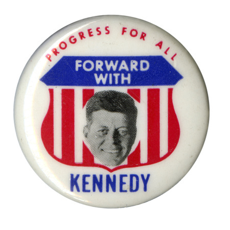 Round, white button with an emblem at the center with a US flag design and a grayscale portrait of John F. Kennedy. Text reads "Progress for All Forward with Kennedy". 