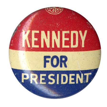 Round button with three horizontal stripes of red, white, and blue. White and blue text reads "Kennedy for President". 