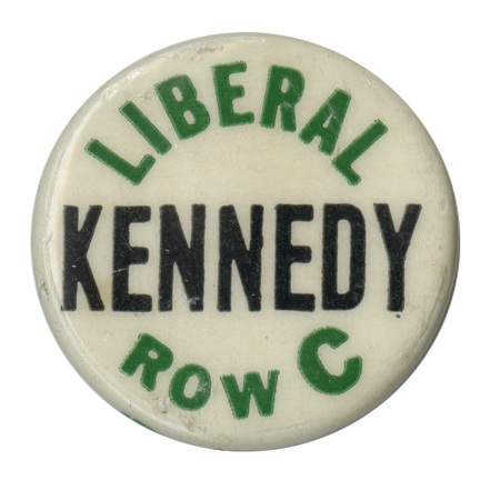 Round, white button with green and black text reading "Liberal Kennedy Row C". 