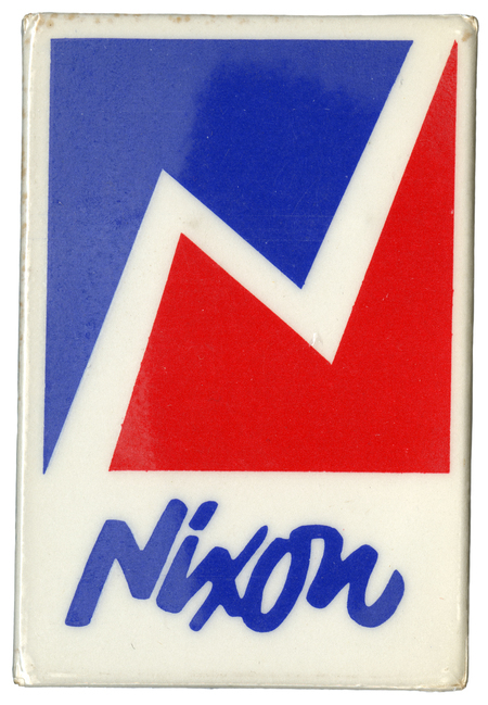 White, rectangular button with a jagged, boxed design of blue and red. Cursive, blue text below the design reads "Nixon". 