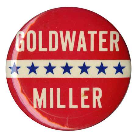 Round, red button with a white stripe across the center and decorative stars across it. White text reads "Goldwater Miller". 