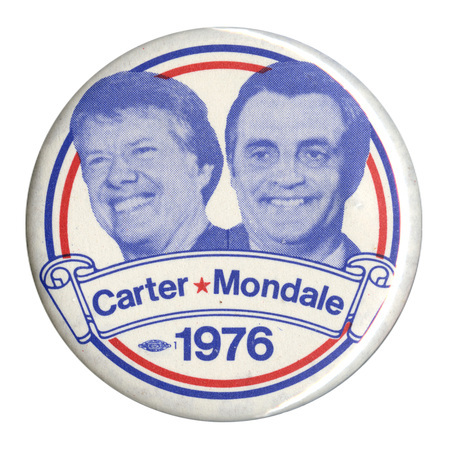 Round, white button with blue portraits of Jimmy Carter and Walter Mondale surrounded by red and blue stripes and scroll decorations. Blue text reads "Carter-Mondale 1976" 