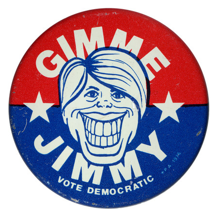 Round, red and blue button with a caricature drawing of Jimmy Carter and white text reading "GIMME JIMMY VOTE DEMOCRATIC"
