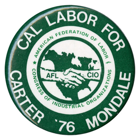 Round, black and white button with a drawing of two hands, labeled "AFL" and "CIO", shaking against a black outline of the United States. White and green text reads "CAL LABOR FOR CARTER '76 MONDALE AMERICAN FEDERATION OF LABOR CONGRESS OF INDUSTRIAL ORGANIZATIONS"