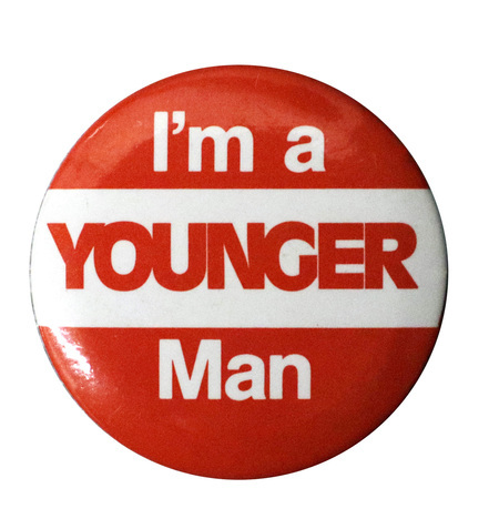 Round, red and white button with white and red text reading "I'm a YOUNGER Man"
