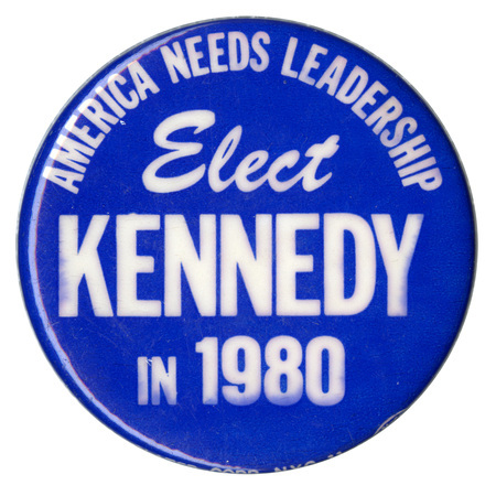 Round, blue button with white text reading "AMERICA NEEDS LEADERSHIP Elect KENNEDY IN 1980"