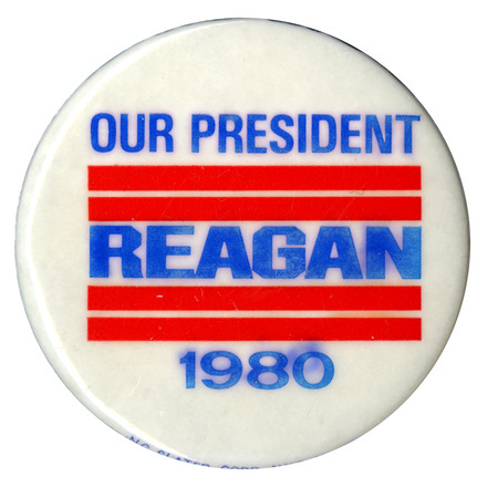 Round, white button with thick red stripes. Blue text reads "OUR PRESIDENT REAGAN 1980"