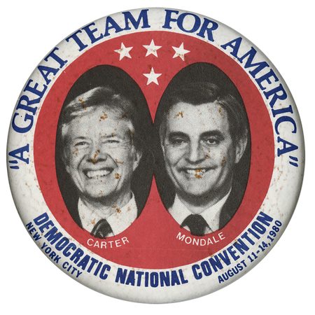 Round button with a white border and red center. Black and white photographs of Jimmy Carter and Walter Mondale occupy black circles in the middle below three white stars. Blue and white text reads ""A GREAT TEAM FOR AMERICA" CARTER MONDALE DEMOCRATIC NATIONAL CONVENTION NEW YORK CITY AUGUST 11-14, 1980"