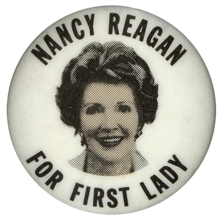 Round, white button with a photograph of Nancy Reagan. Black text redas "NANCY REAGAN FOR FIRST LADY"