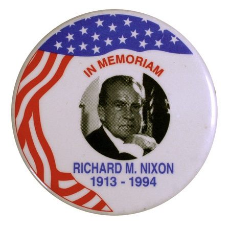 Round, white button with a black and white portrait of Richard Nixon surrounded by red and blue flag decorations. Red and blue text reads "In memoriam, Richard M. Nixon, 1913-1994."