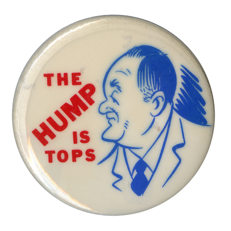Round, white button with a blue line drawing caricature of Hubert Humphrey and red text reading "The hump is tops."