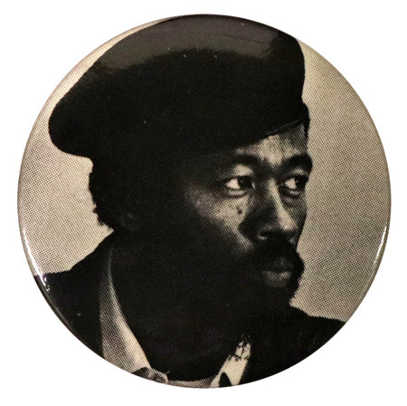 Round, black and white button with a portrait of Eldridge Cleaver.