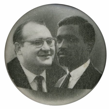 Round, black and white button with portraits of Fred Halstead and Paul Boutelle.