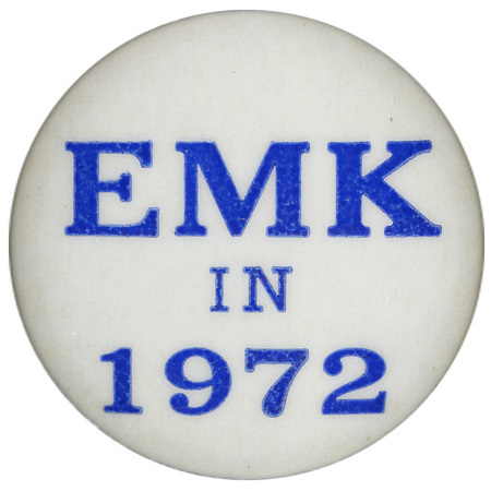 Round, white button with blue text reading "EMK in 1972."