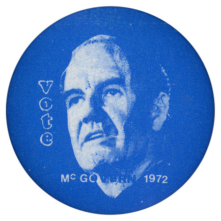 Round, blue button with a portrait of George McGovern and white text reading "Vote McGOVERN 1972"