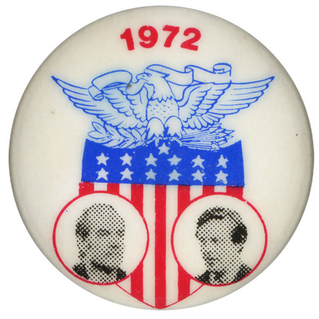 Round, white button with black and white portraits of George McGovern and Thomas Eagleton set against a red, white, and blue shield topped by a blue eagle. Red text reads "1972"