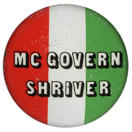 Round, button with bands of red, white, and green and black text reading "McGOVERN SHRIVER"