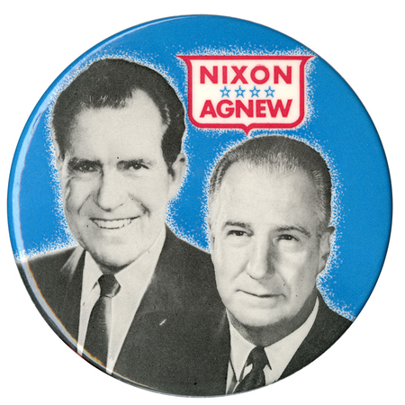 Round, blue button with black and white portraits of Richard Nixon and Spiro Agnew. Red text within a red, white, and blue shield reads "NIXON AGNEW"