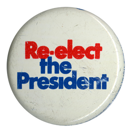 Round, white button with red and blue text reading "Re-elect the President"
