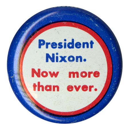 Round, white button edged in blue and red. Blue and red text reads "President Nixon. Now more than ever."