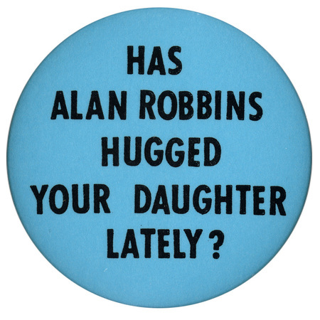 Round, blue button with black text reading "HAS ALAN ROBBINS HUGGED YOUR DAUGHTER LATELY?"