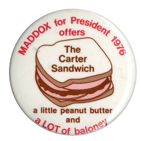 Round, white button with an image of a peanut butter and baloney sandwich on white bread. Red and brown text reads "MADDOX for President 1976 offers The Carter Sandwich a little peanut butter and a LOT of baloney"