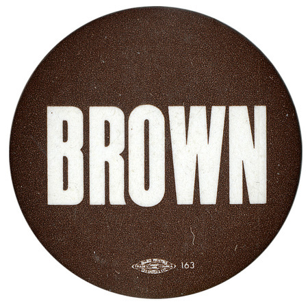 Round, dark button with white text reading "BROWN"