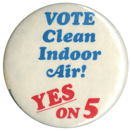 Round, white button with blue and red text reading "VOTE Clean Indoor Air! YES ON 5"