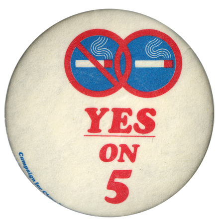 Round, white button with two red, white, and blue images of smoking cigarettes within a circle, one of them crossed out. Red text reads "YES ON 5"