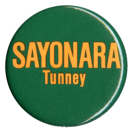 Round, dark green button with yellow text reading "SAYONARA Tunney"