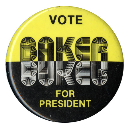 Round button with a yellow upper half and black lower half. Black, white and yellow text reads "VOTE BAKER FOR PRESIDENT". "BAKER" is mirrored in the middle of the button.