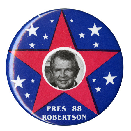 Round, blue button with a large red star and several small white stars. In the center is a black and white photograph of Pat Robertson. White text reads "PRES 88 ROBERTSON"