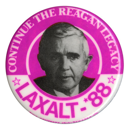 Round, purple and white button with a black and white photograph of Paul Laxalt. White and purple text reads "CONTINUE THE REAGAN LEGACY LAXALT-'88"